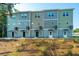 Exterior view showcasing a row of modern townhomes with mixed green and gray siding and front entrances at 208 Cache Ct, Charleston, SC 29414