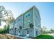New townhomes featuring a mix of green and gray siding with attached garages and private entrances at 208 Cache Ct, Charleston, SC 29414