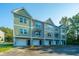 Exterior view of new townhomes with a combination of green and gray siding and private garage entrances at 208 Cache Ct, Charleston, SC 29414