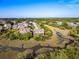 An aerial view shows the beautiful real estate with mature trees lining the stream and marsh front views at 2087 Sterling Marsh Ln, Seabrook Island, SC 29455