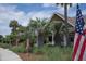 Inviting exterior with palm trees and American flags, showcasing a patriotic and tropical ambiance at 2087 Sterling Marsh Ln, Seabrook Island, SC 29455