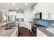 A bright kitchen with stainless steel appliances, granite countertops, and white cabinetry offers a stylish and functional space at 2087 Sterling Marsh Ln, Seabrook Island, SC 29455