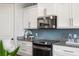 Close-up view of a modern kitchen featuring stainless steel appliances, subway tile backsplash, and granite countertops at 2087 Sterling Marsh Ln, Seabrook Island, SC 29455