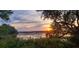 Peaceful water view reflecting the sunset with framed by lush foliage, creating a tranquil and scenic environment at 2087 Sterling Marsh Ln, Seabrook Island, SC 29455