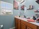 Well-lit bathroom with a wood vanity, countertop with toiletries, round mirror, and a Venice-themed picture above the toilet at 216 Goldfinch Ln, Summerville, SC 29485