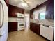 Well-lit kitchen featuring dark wood cabinets, white appliances, a window over the sink, and vinyl floors at 2173 Annie Laura Ln, Mount Pleasant, SC 29466