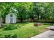 Large backyard featuring a storage shed, brick fire pit, lush green grass, and privacy fence at 2515 Violet Ave, North Charleston, SC 29405