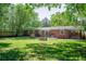 Spacious backyard with lush grass, a brick patio, brick fire pit, and mature trees at 2515 Violet Ave, North Charleston, SC 29405