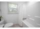 Bright bathroom featuring a shower over tub with a white curtain and a window at 2515 Violet Ave, North Charleston, SC 29405