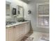 Bathroom featuring a double sink marble vanity, seagull art, mirrors, and shuttered windows at 2655 Gnarled Pine, Seabrook Island, SC 29455