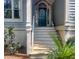 Close-up of a charming porch with a teal front door, decorative wreath, and traditional architectural details at 2655 Gnarled Pine, Seabrook Island, SC 29455