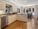 Open kitchen with stainless steel appliances, white cabinetry, and granite countertops leading to dining area at 2655 Gnarled Pine, Seabrook Island, SC 29455
