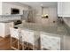 Bright kitchen with white cabinets, stainless steel appliances, granite countertops, and bar seating at the island at 2655 Gnarled Pine, Seabrook Island, SC 29455