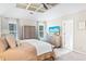 This main bedroom has two windows, a ceiling fan, a TV, carpet and a closet with wooden doors at 2655 Gnarled Pine, Seabrook Island, SC 29455