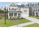 Inviting two-story home with a landscaped yard, covered front porch, and attached two-car garage at 283 Saxony Loop, Summerville, SC 29486