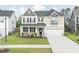 Charming two-story home with a manicured lawn, covered porch, and two-car garage at 283 Saxony Loop, Summerville, SC 29486