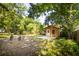 Backyard with a shed under shady trees, featuring a small deck, outdoor seating, and plenty of green space at 2963 Alabama Dr, North Charleston, SC 29405