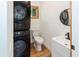 Compact laundry area featuring a stacked washer and dryer, toilet, and a sleek modern sink at 2963 Alabama Dr, North Charleston, SC 29405