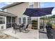 Back patio with outdoor dining set, rocking chairs, an umbrella and plant stand at 301 Edenton Rd, Goose Creek, SC 29445