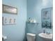 Light blue bathroom featuring white toilet and sink, decor, and vanity mirror at 301 Mondo Ct, Summerville, SC 29486