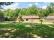 A spacious brick home with a well-maintained lawn, small palm tree, privacy fence, and seating area at 305 Forest Cir, Summerville, SC 29483