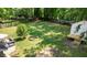 A spacious, green backyard featuring a storage shed with stairs, a charcoal grill, and a seating area at 305 Forest Cir, Summerville, SC 29483