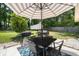 Outdoor dining area with a table, chairs, grill, and umbrella, perfect for entertaining at 305 Forest Cir, Summerville, SC 29483