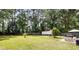 A spacious, fenced backyard with a shed, seating area, small palm tree, and lush green grass at 305 Forest Cir, Summerville, SC 29483