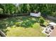 An expansive fenced backyard with a storage shed, a seating area with an umbrella, and a small palm tree at 305 Forest Cir, Summerville, SC 29483