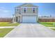 Two-story home featuring a two-car garage, well-maintained lawn, and charming curb appeal on a bright day at 307 Fox Gap Rd, Summerville, SC 29486