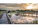 View of a wooden dock with boats and a serene waterfront view under a cloudy sky at sunset at 3130 Pignatelli Cres, Mount Pleasant, SC 29466