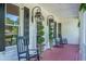 Close-up of front porch with black rocking chairs, decorative plants, and traditional lantern fixtures at 3130 Pignatelli Cres, Mount Pleasant, SC 29466