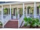 Inviting front porch with decorative columns, rocking chairs, stylish lanterns, and lush greenery at 3130 Pignatelli Cres, Mount Pleasant, SC 29466
