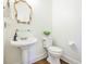 This powder room features a pedestal sink, decorative mirror, and hardwood floors at 3130 Pignatelli Cres, Mount Pleasant, SC 29466