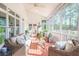 Inviting screened porch with wicker furniture, ceiling fan, and views of the surrounding greenery at 3130 Pignatelli Cres, Mount Pleasant, SC 29466