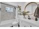 Bright bathroom featuring marble tiled shower, round mirror, and stylish vanity at 3428 Plaza Ln, North Charleston, SC 29420