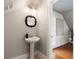 Cozy bathroom featuring a pedestal sink, decorative mirror, and access to the bright bonus room at 3508 Henrietta Hartford Rd, Mount Pleasant, SC 29466