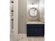Charming bathroom with a navy vanity, granite countertop, round mirror, and modern fixtures at 3508 Henrietta Hartford Rd, Mount Pleasant, SC 29466