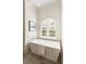 Modern bathtub with window and shutter, towel and artwork at 3508 Henrietta Hartford Rd, Mount Pleasant, SC 29466