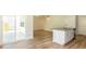 Open-concept layout with wood flooring, seamless transition to the kitchen, and access to an outdoor patio at 413 Mistflower Ln, Moncks Corner, SC 29461