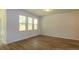 Bright living room features wood-look flooring and ample natural light from three large windows at 413 Mistflower Ln, Moncks Corner, SC 29461