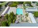 Aerial shot of pool with lounge chairs and umbrellas surrounded by colorful buildings and lush greenery at 4631 Scout Aly, North Charleston, SC 29405