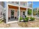 Charming front porch with rocking chairs, plants, and a welcoming wreath on the front door at 4631 Scout Aly, North Charleston, SC 29405