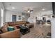 Open-concept living room flows into dining area with brown leather sectional sofa, ceiling fan and wood floors at 4631 Scout Aly, North Charleston, SC 29405