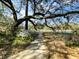 A park walking path is canopied by a mature tree with bright green plants and calm water in the distance at 4631 Scout Aly, North Charleston, SC 29405