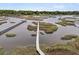 Wide aerial view featuring a marshy coastline and a long wooden pier with docks at 4702 Blockhouse Ln, Hollywood, SC 29449