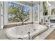 Soaking tub with jets in a bright bathroom with a large window and views at 4702 Blockhouse Ln, Hollywood, SC 29449