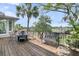 A beautiful wooden deck features chairs and benches overlooking a tranquil landscape with a view of tropical palm trees at 4702 Blockhouse Ln, Hollywood, SC 29449