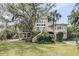 Back of the house overlooking the backyard with a large yard and mature trees at 4702 Blockhouse Ln, Hollywood, SC 29449