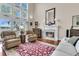 Bright living room with a fireplace, tall windows, wood floors, and comfortable seating at 4702 Blockhouse Ln, Hollywood, SC 29449